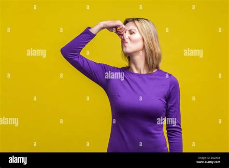 Bad Smell Portrait Of Young Woman In Purple Dress Standing Pinching