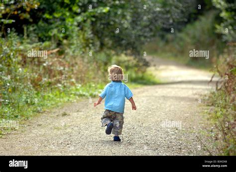 Child Running Alone Along A Country Path Stock Photo Alamy