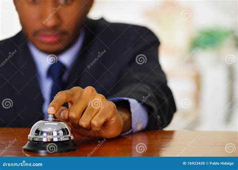 Man Wearing Elegant Blue Suit Pressing Desk Bell At Hotel Reception