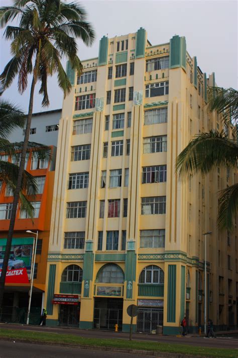 A Tall Yellow Building Sitting Next To Palm Trees