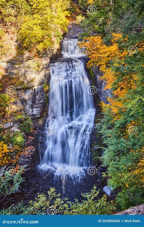 Vertical Close Of Large Waterfall From Above Surrounded By Cliffs And