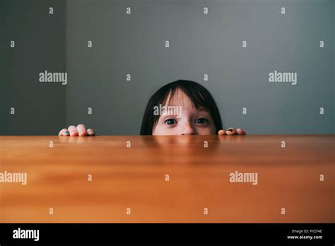 Girl Hiding Behind A Table Stock Photo Alamy