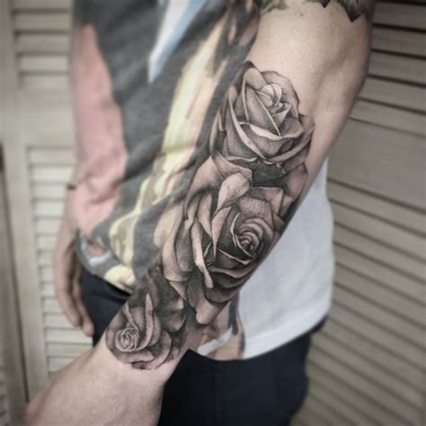 A Man With A Black And White Rose Tattoo On His Arm