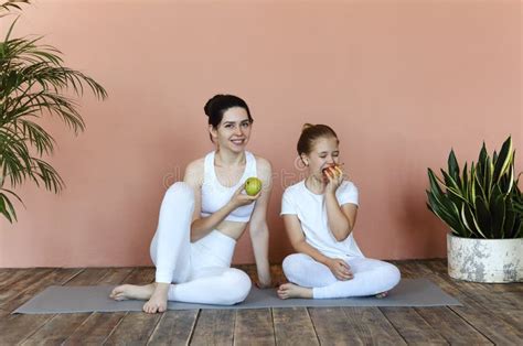 Smiling Mother And Daughter Eating Fruits After Practicing Yoga