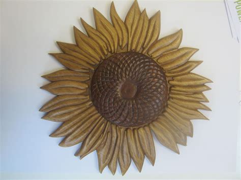 A Wooden Sunflower Is Hanging On The Wall