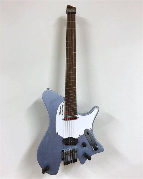 A Blue And White Electric Guitar Hanging On The Side Of A Wall With A