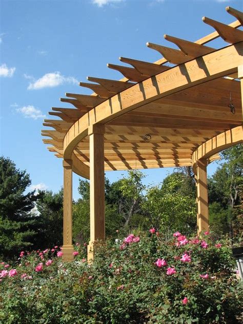 A Wooden Pergola Sitting On Top Of A Lush Green Park Covered In Flowers