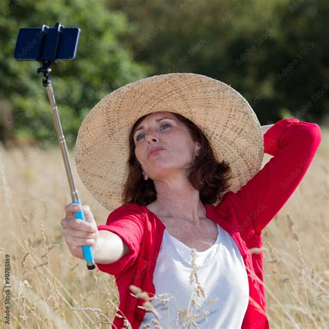 Mature Selfie Concept Sexy Aging Woman Enjoying Taking A Selfie With A Stick In Summer Dry