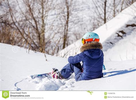 Photo From Back Of Athlete In Helmet Sitting On Snowy Slope Stock Image