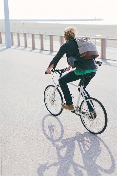 Man Riding Bike Over A Boulevard Along The Beach By Stocksy Contributor Denni Van Huis