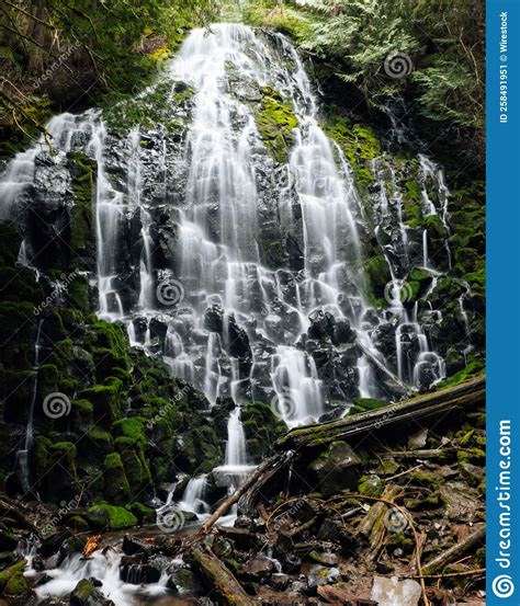 Vertical Shot Of A Cascade Waterfall Flowing On The Mossy Cliff Stock