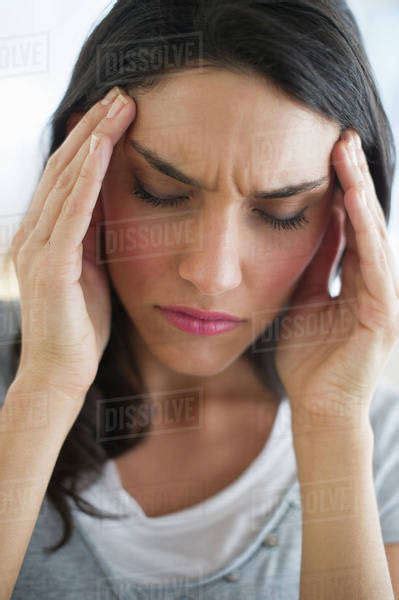 Woman Suffering From Headache Holding Head In Hands Stock Photo