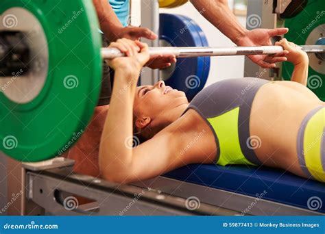 Woman Bench Pressing Weights With Assistance Of Trainer Stock Image Image Of Determination