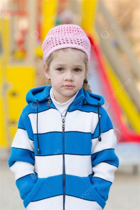 فتاة تبلغ من العمر أربع سنوات تلعب في الملعب في صورة طقس ربيعي بارد لفتاة تبلغ من العمر أربع