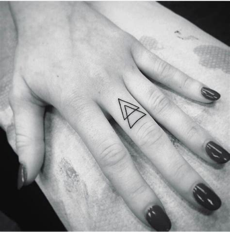 A Womans Hand With A Small Triangle Tattoo On It