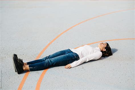 Woman Lying On Playground By Stocksy Contributor Javier Díez Stocksy