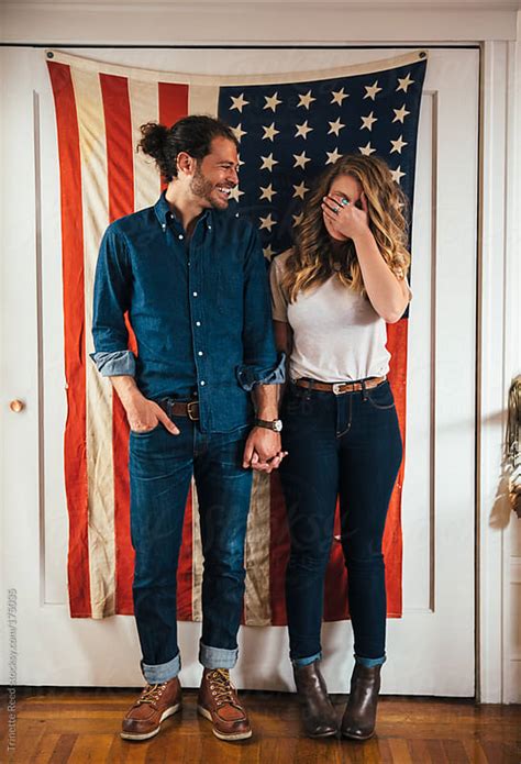 hipster couple standing in front of american flag by trinette reed stocksy united