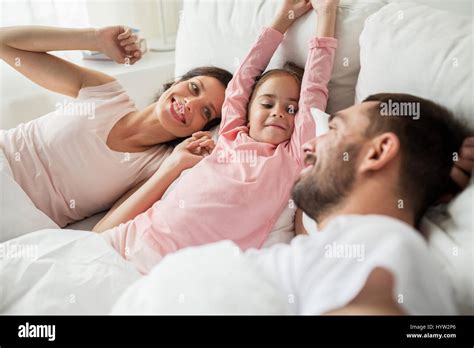 Familia Feliz De Despertarse En La Cama En Casa Fotografía De Stock Alamy