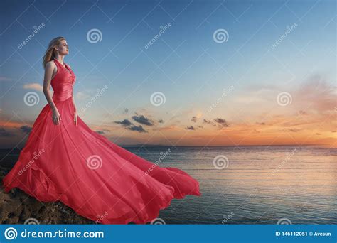 Belle Jeune Femme Posant Dans La Longue Robe Luxueuse Sur La Plage
