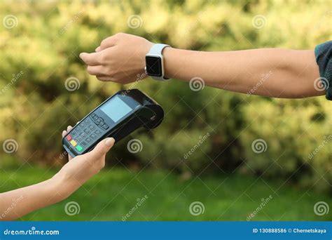 Woman Using Terminal For Contactless Payment With Smart Stock Photo