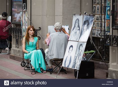 Beautiful Young Woman Having Portrait Drawn By Artist In Arbat Street