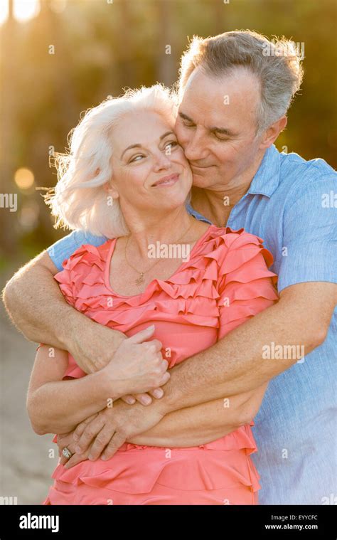 Older Caucasian Couple Hugging On Beach Stock Photo Alamy