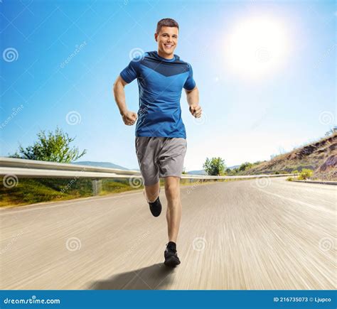 Man Running Towards The Camera On An Open Asphalt Road Stock Image