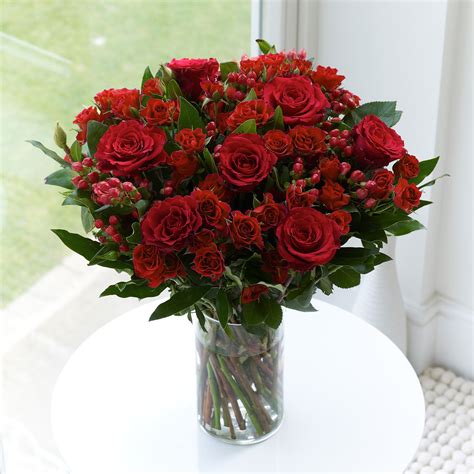 A lush arrangement of red, pink, and burgundy blooms? A beautiful red rose display for your wedding table. | Red ...