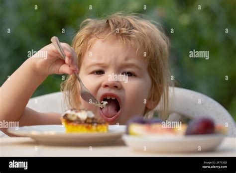 Feeding Kids Child Eating Cake In The Garden Outside In Summer Baby