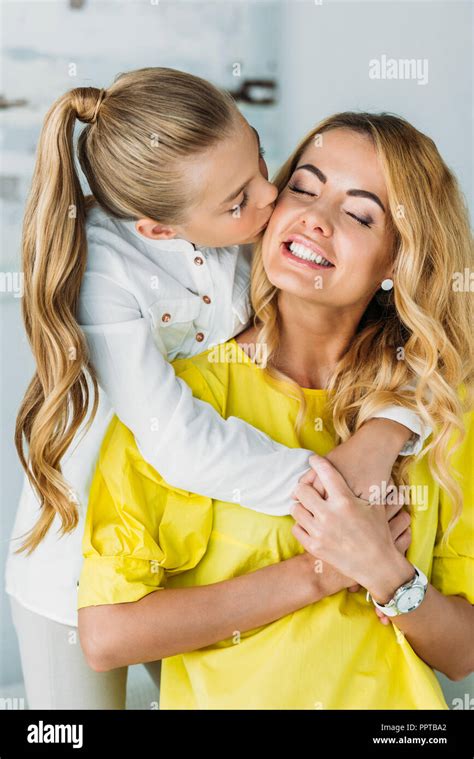Adorable Little Daughter Embracing Mother From Behind And Kissing Her