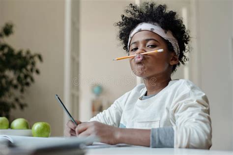 Funny Schoolboy In Headband Holding Pencil Between Upper Lip And Nose
