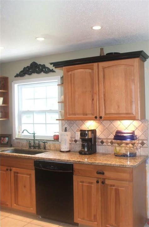 Crown molding that sits atop kitchen cabinets gives them a solid, finished look. Image result for black countertops with oak cabinets -What ...