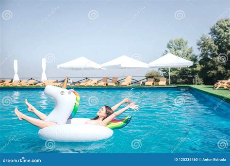 Happy And Satisfied Girl Is Lying On Air Mattress In The Middle Of Swimming Pool She Keeps
