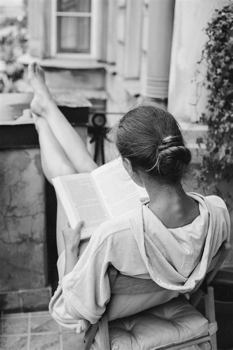Woman Reading A Book At The Balcony By Stocksy Contributor Amor Burakova Stocksy