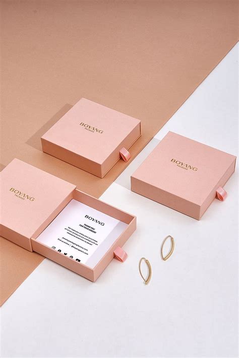 Three Pink Boxes Sitting Next To Each Other On Top Of A White Table