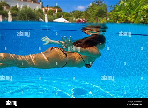 Woman In Bikini Diving Underwater In Swimming Pool Hotel Above Water