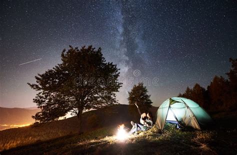 Couple Tourists Resting At Night Camping Under Stars Stock Photo