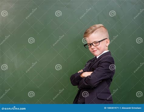 Young Boy With Crossed Arms Standing Near Chalkboard Stock Image