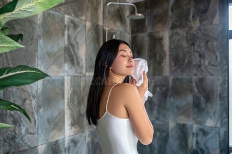 Brunette Female Standing In Shower In Night Dress Wiping Her Face With Towel Stock Image