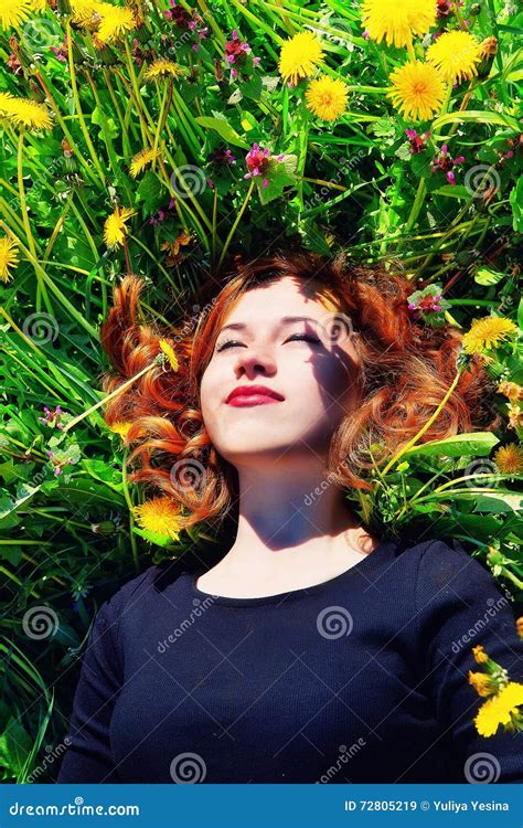 girl with red hair lying on the field of dandelions stock image image of beauty bright 72805219