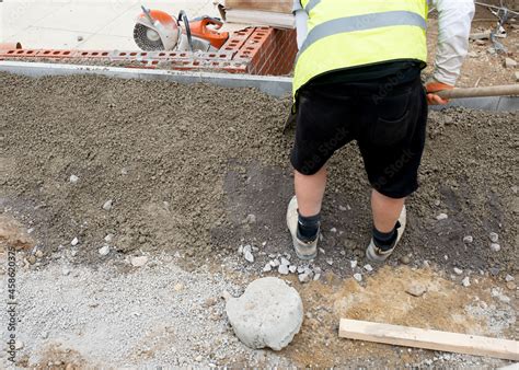 Groundworker Placing Edging Pin Kerb On Semi Dry Concrete During