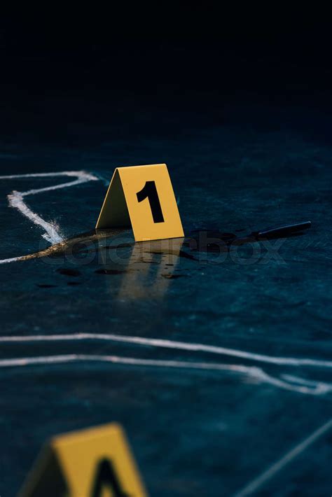 Selective Focus Of Chalk Outline And Evidence Markers At Crime Scene