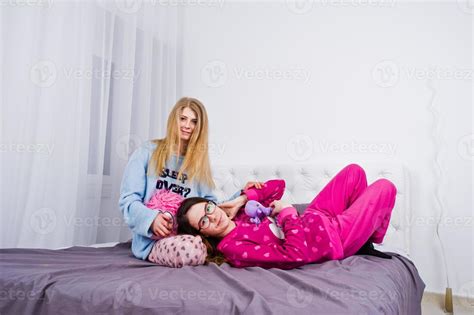 two friends girls in pajamas having fun on bed at room 10489971 stock