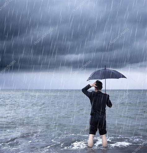 Upset Business Man Holding A Umbrella With Cloudburst Background Stock