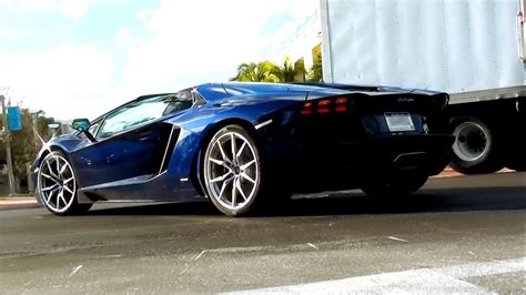Two Dark Blue Lamborghini Aventador Lp700 4 Roadsters Driving In Miami