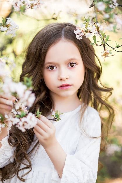 Retrato De Una Hermosa Niña En Un Jardín Floreciente De Primavera Una