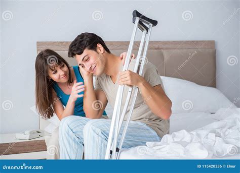 The Young Wife Supporting Husband On Crutch After Injury Stock Photo