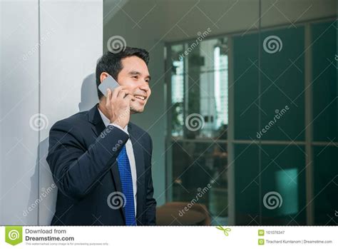 Businessman Using Mobile Phone App Texting Outside Of Office In Urban