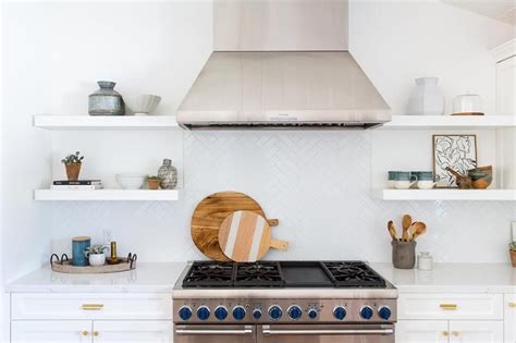 Laurel and her husband had spent $2,500 on the stainless suite. White floating shelves decorate a stainless steel vent ...