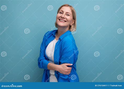 close up of a cute mature woman in a shirt on a blue background with copyspace stock image